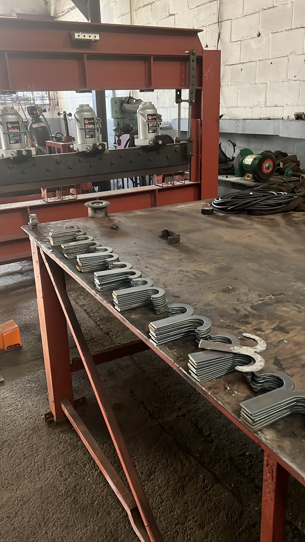Batch of completed CNC-cut gate fittings arranged in the workshop