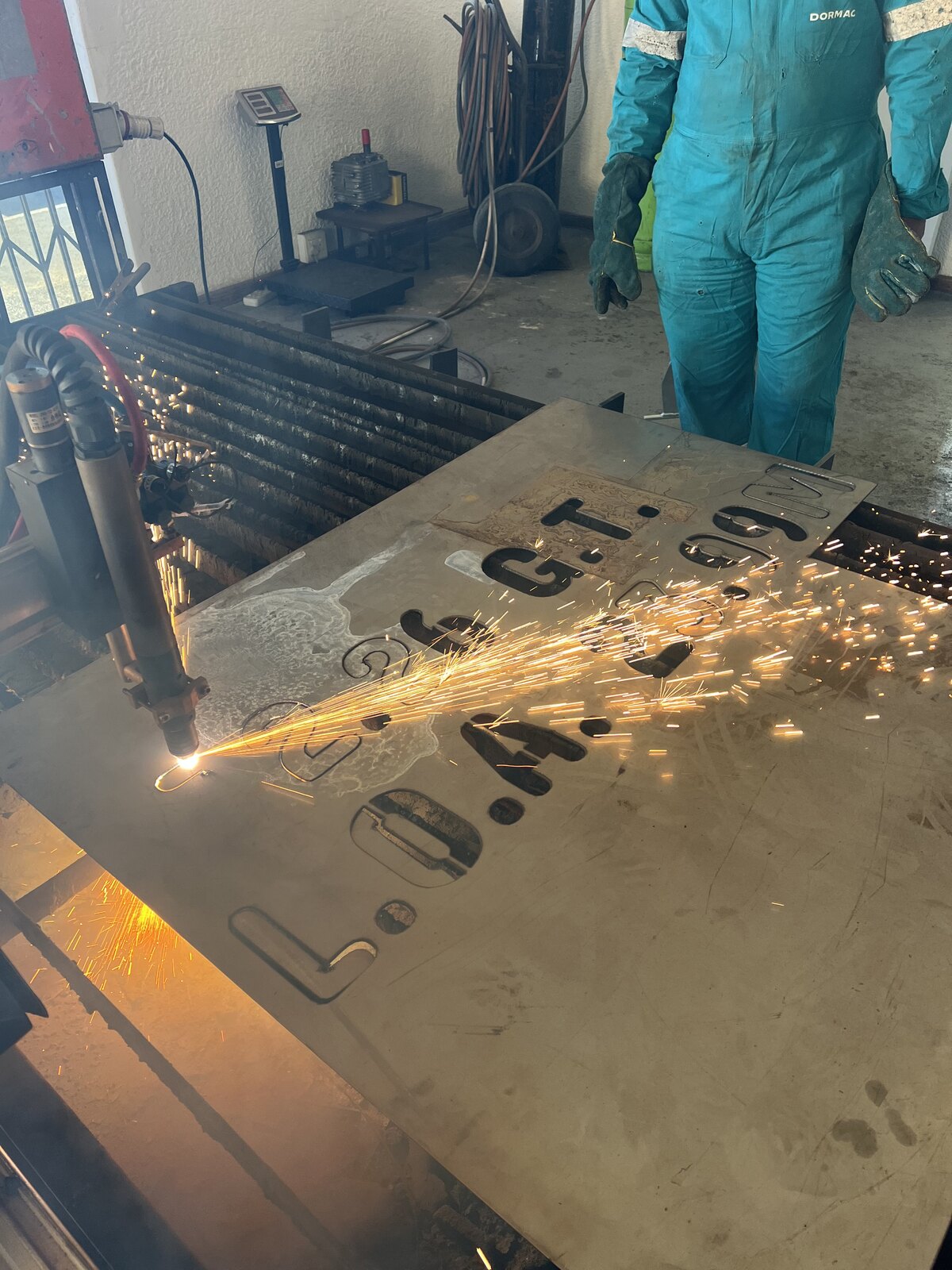 CNC plasma torch cutting vessel identification markings from steel plate