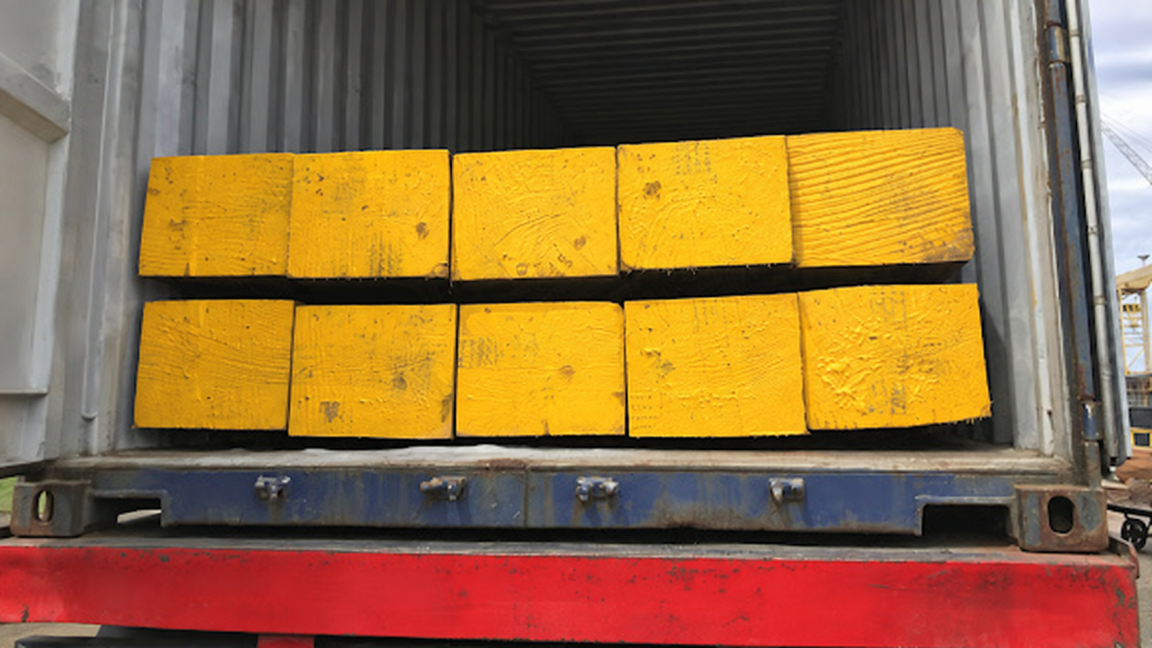 Ten imported Greenheart timber sections stacked inside a shipping container