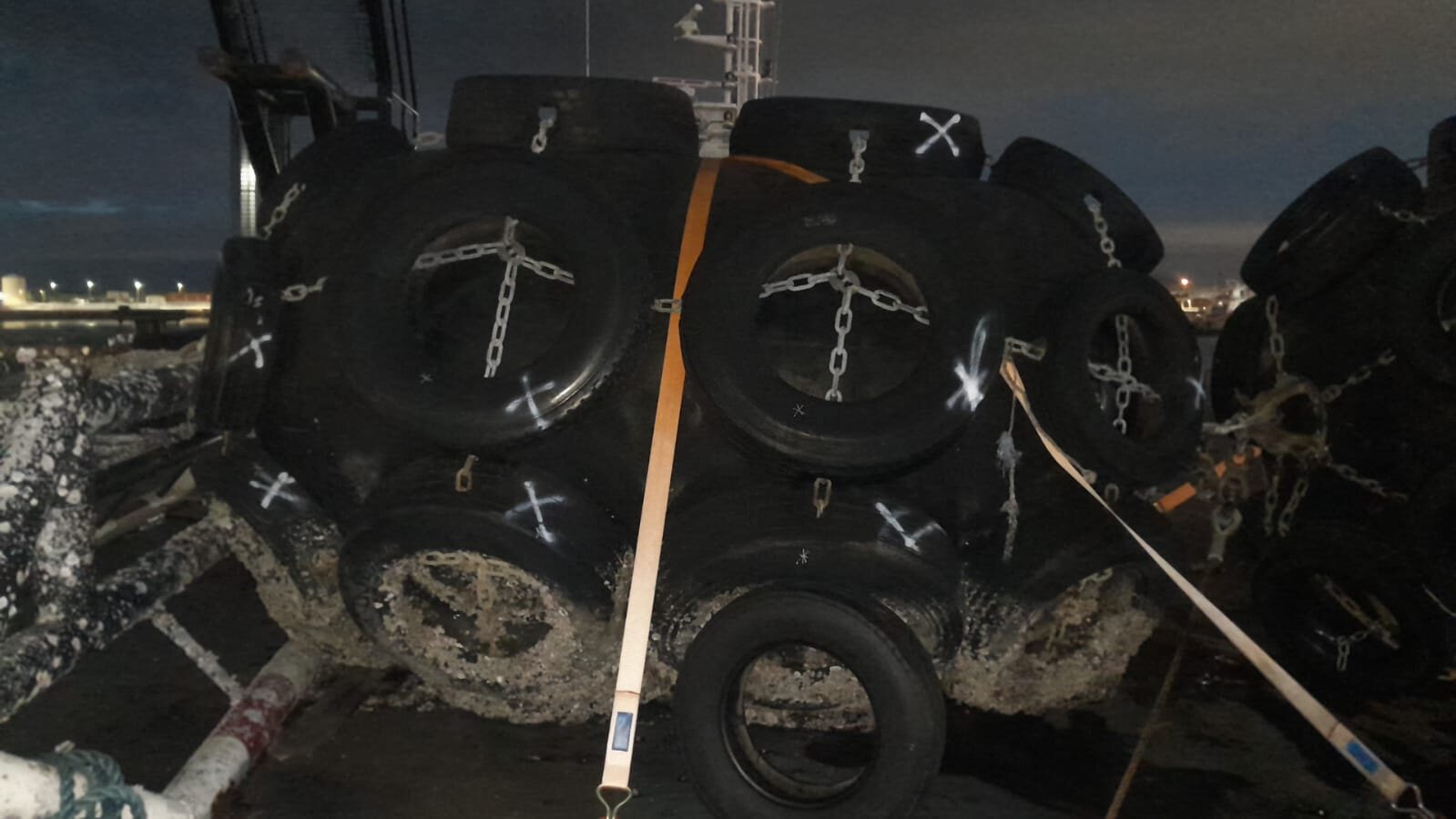 Removed and replacement fender tyres staged on deck
