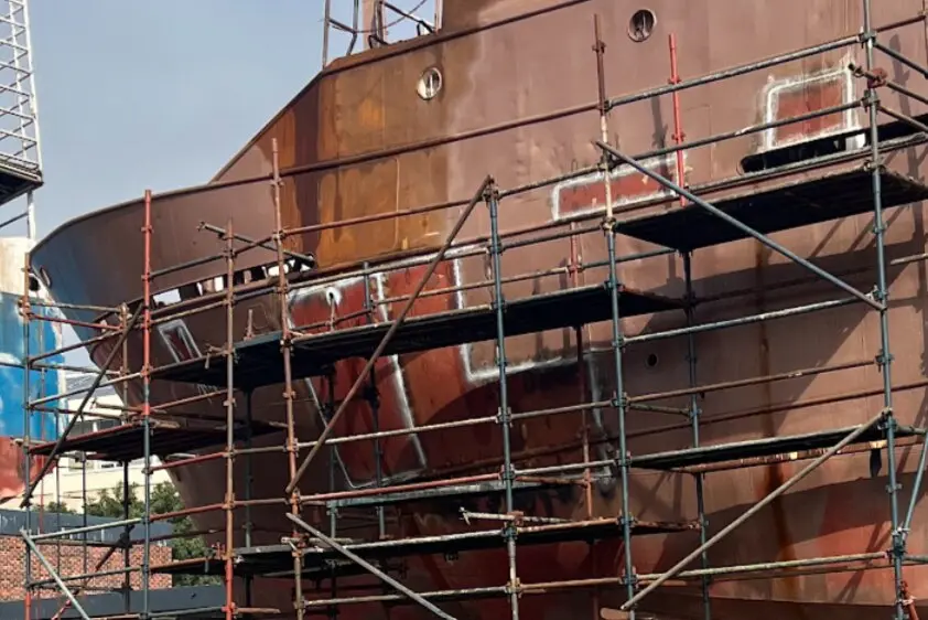 Hull plate inserts with visible NDT developer around welded perimeters